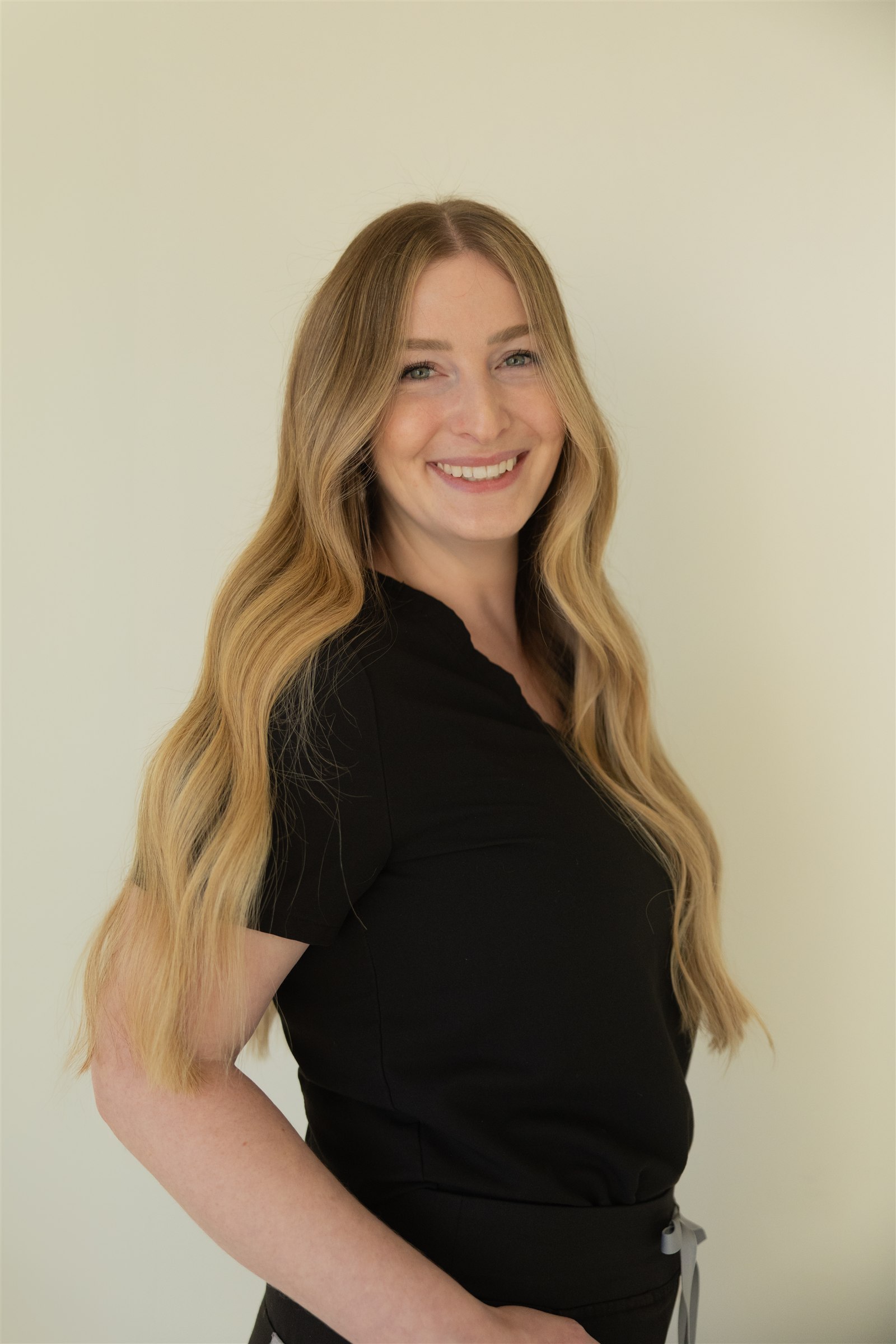 Madison Prim smiling warmly in black clinical attire